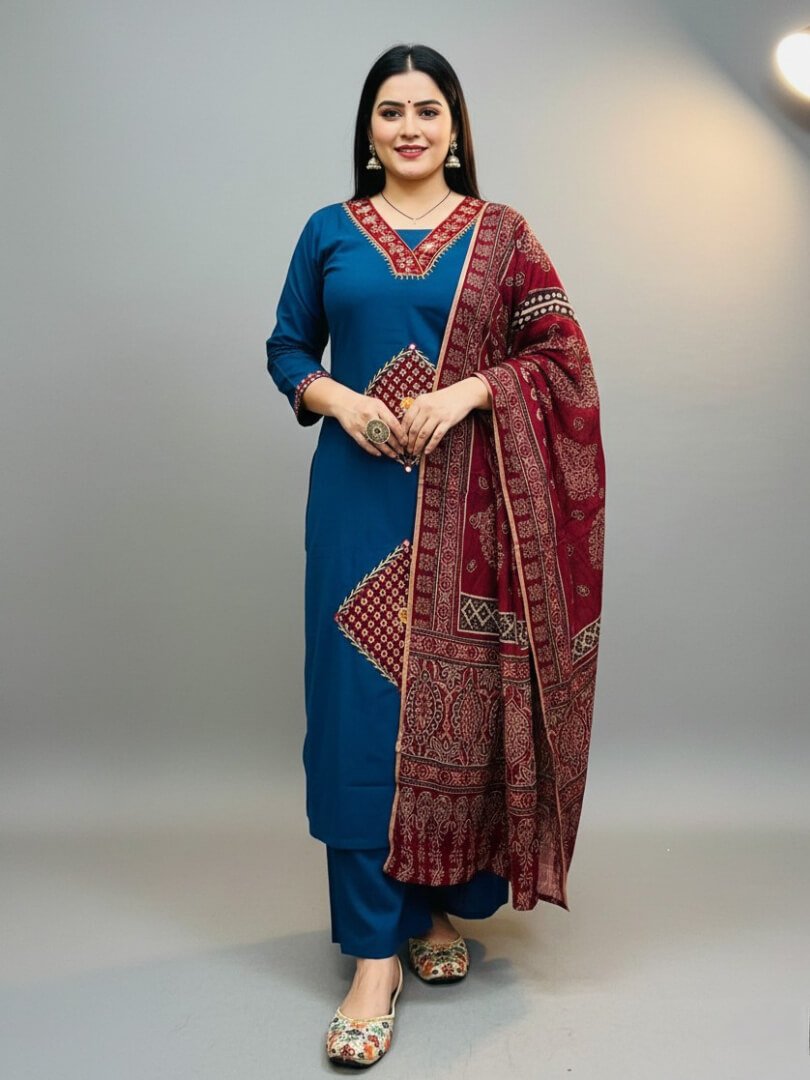 Feel the elegance with a blue cotton kurti with mirror work, paired with pants and a maroon printed dupatta.
